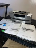 Overall view of Bose Wave Music System main unit with multi-CD changer, two remotes and manuals