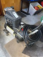 Full view of Husky air compressor showing attached hose and wheels for portability.