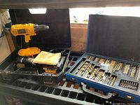 Overall view of drill, battery, charger and bit case in black carrying case