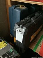 Closed view of DeWalt carrying case with Mastercraft blue drill case behind it