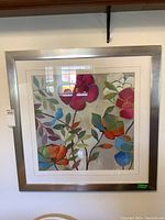 Full front view of the framed floral print artwork showing colorful flowers in a silver metal frame.