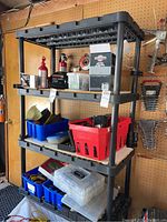 Front view of one shelving unit containing various containers and tools.