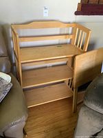 Full view of the wooden shelf unit showing three shelves and side railings