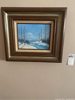 Full view of framed winter scene painting with snow, trees, and bridge.