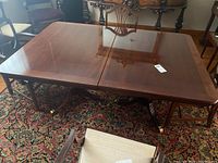 Singer wooden dining table with brass capped feet, showing surface and overall condition.