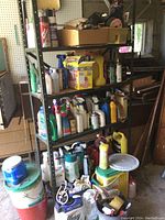 Full shelf with multiple bottles and containers of garden chemicals, sprays, and tools.
