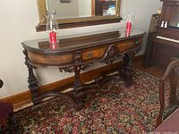 Front view of Mohlhenrich carved wooden server/sideboard with decorated drawer and glass top, showing full length and ornate legs.