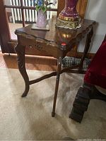 Side table showing top view with carved detailing and curved legs.