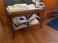Wooden side table with contents placed on and underneath it.