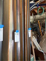 View of folded tables showing wooden tabletops and metal edges vertically stacked