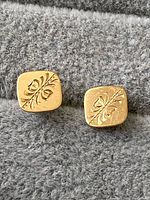 Front view of the pair of 14K yellow gold square earrings showing engraved floral design on each.