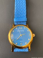 Front view of Joan Rivers Classics watch with blue dial and crystal hour markers, gold-tone case, and blue woven strap.