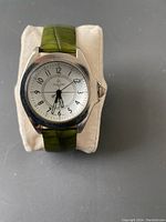 Front view of Joan Rivers Classics wristwatch showing watch face and green textured leather band partially.