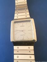 Front view of men's Adec quartz watch showing square face and metal link band.