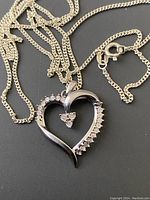 Close-up image of sterling silver heart pendant with diamonds on chain with lobster clasp.