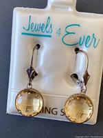 Pair of drop sterling silver earrings with round citrine gemstones set in silver bezels, displayed on Jewels 4 Ever branded card.
