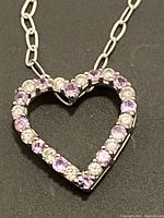 Close-up of the heart-shaped pendant showing alternating white topaz and amethyst stones set in sterling silver.