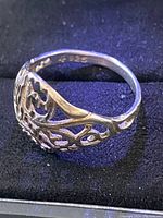 Close-up front and side view of sterling silver filigree ring size 6.5 showing intricate openwork design and 925 sterling silver stamp inside band.