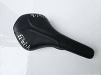 Top and angled side view of black Fizik bike saddle.