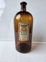 Full view of Dickinson's Witch Hazel bottle showing amber glass body and original label.