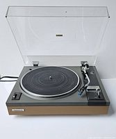 Full view of the Pioneer turntable with clear dust cover open, showing platter, tonearm, and cartridge.