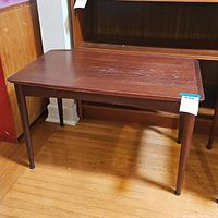 Full view of the table showing rectangular top with surface scratches and four tapered legs