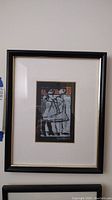 Full view of framed print artwork showing abstract figures and artist signature.