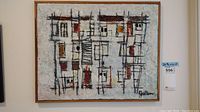 Full frontal view of signed abstract geometric fabric art in wood frame