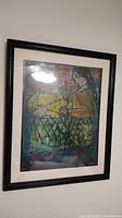 Full view of framed and matted abstract print featuring two figures, visible colors and texture with black frame.