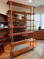 Full front view of five-tier bookshelf against backdrop of matching units