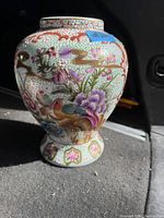 Front view of Asian porcelain vase showing colorful floral and bird design with gold highlights.