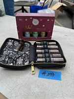 Front view of Holiday Collection essential oils box with lavender, peppermint, and eucalyptus oils visible, along with the open Saje Pocket Pharmacy roll-on essential oil case showing seven roll-on bottles.