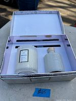 Open box showing a Mokara scented candle, a reed diffuser bottle, and reed sticks arranged inside.