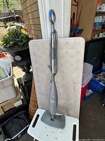 Full view of the Shark electric steam mop standing upright, showing handle, body, and mop head.