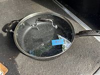 Top view of the frying pan with the glass lid and label #230 on the lid.