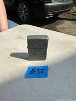 Closed view of the vintage Zippo lighter showing grey speckled metal finish.