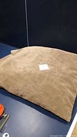 Photo showing the dog bed with the corduroy textured removable cover intact, beige/light brown color.