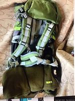 Photo of the green hiking backpack showing padded shoulder straps and adjustable waist strap.