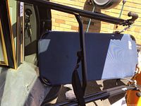 Folded inversion table showing blue padded backrest and black steel frame with ankle holders.