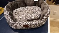 Front view of the grey and ivory patterned dog bed with a thick, cushioned interior and removable pillow cushion inside.