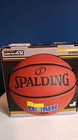 Front view of the Spalding basketball in its original box showing the ball size and branding.