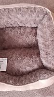 Top view of small soft dog bed showing light gray plush fur lining and cushioned interior.
