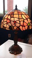 Full view of lamp showing stained glass shade and metal base