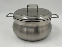 Front and side view of the stainless steel cooking pot with lid, showing overall shape and handles.