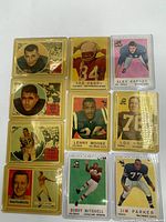 Photo showing a set of 10 vintage football cards in protective sleeves, laying flat on a white surface.