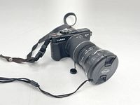 Front angle showing the Panasonic Lumix DMC-GX1 digital camera with the Lumix 14-42mm lens attached and camera strap visible.