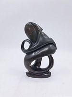 Front and side view of the soap stone abstract sculpture showing its curved and looped design.