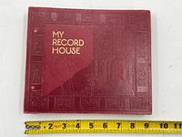 Closed burgundy My Record House binder with embossed gold title and decorative border, measured about 10 inches wide.