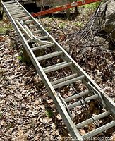 Close view of the 40 ft aluminum ladder placed on ground showing rungs and stabilizers present