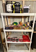 Three-tier white plastic shelving with assorted bits and sockets organized in trays and packaging, with electric heater and cooling fan on top.